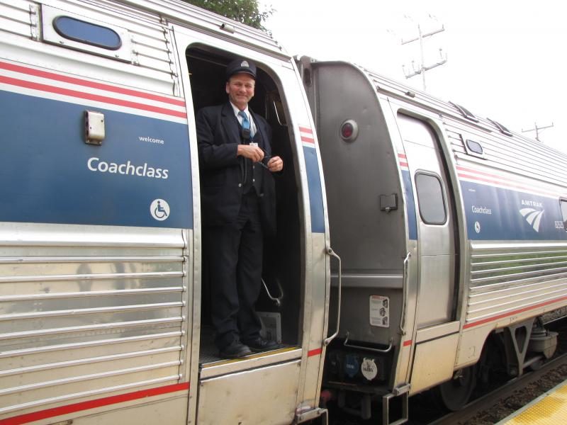 amtrak_downeaster_conductor_standing_in_amfleet_car_doorway-9772125